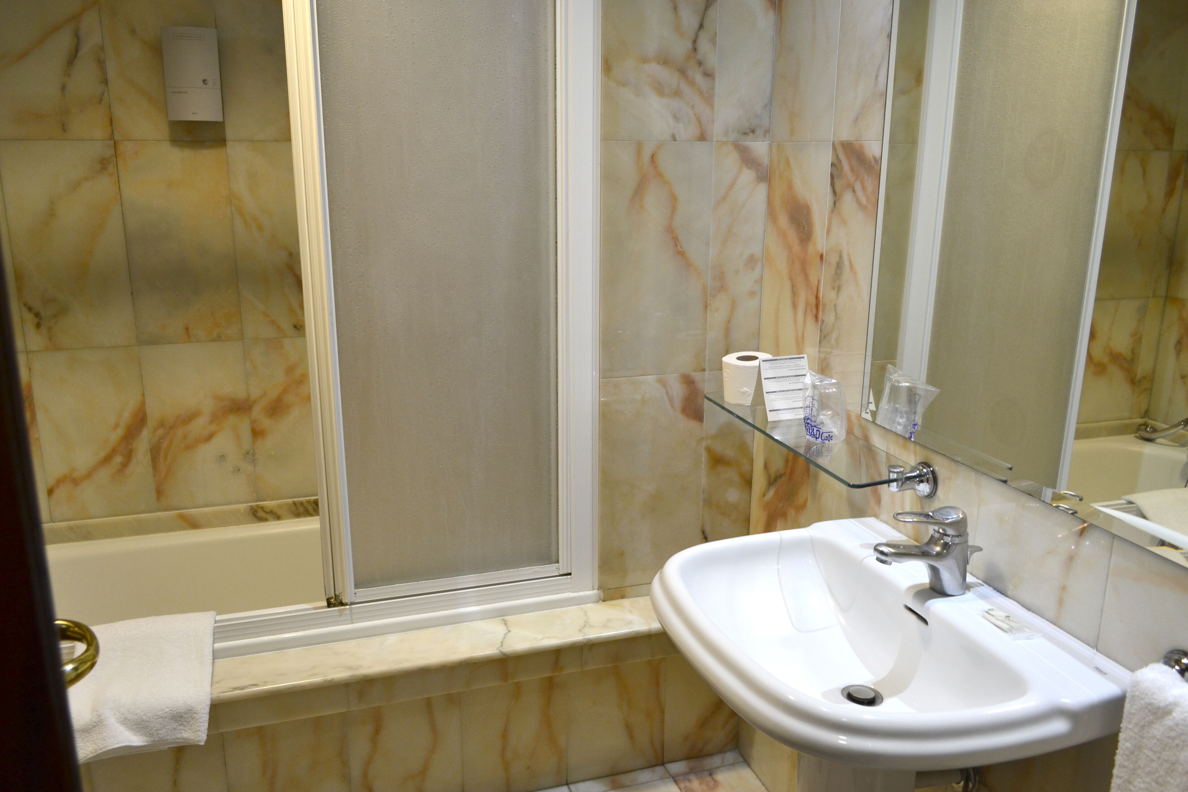 Un baño con bañera, lavabo y cabina de ducha de vidrio.