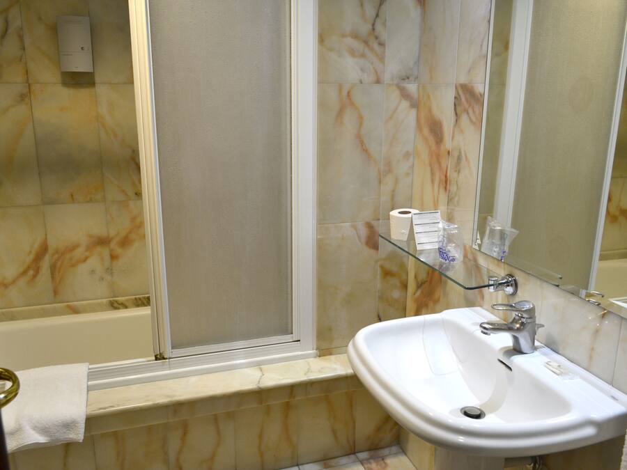 Un baño con bañera, lavabo y cabina de ducha de vidrio.