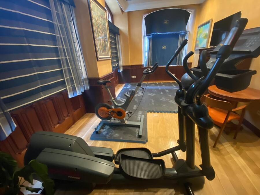 A home gym with a stationary bike, elliptical, and treadmill.