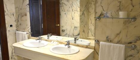 A bathroom with two sinks, a mirror, and a towel rack.