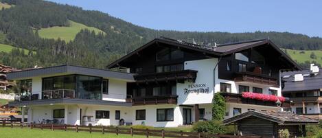 A two-story building with a sign reading "Pension Strangl".