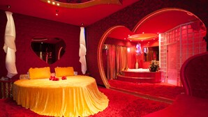 A luxurious bedroom with a large bed, heart-shaped mirror, and a red carpet. - Priamos - Adults Only (Athens)