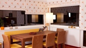 Un comedor con una mesa y sillas de madera, un banco y una figurita decorativa de ciervo.