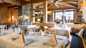 A cozy restaurant with wooden beams, stone walls, and tables set for dining. - Traube am See (Friedrichshafen)