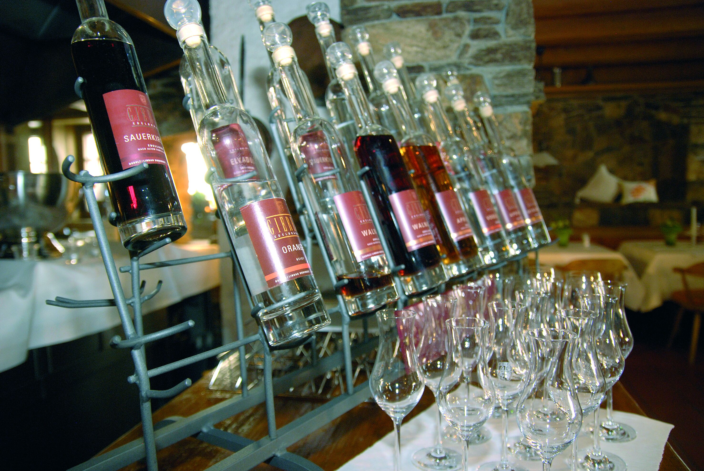 A wine rack with multiple bottles and several empty wine glasses.