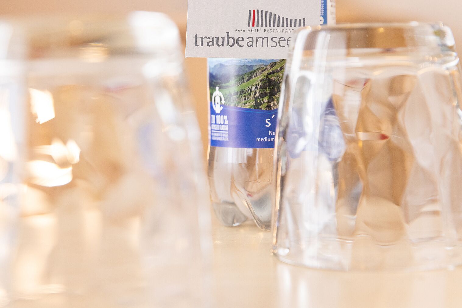 Un restaurante de hotel con vasos transparentes y un atril para el menú.