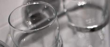 Primer plano de botellas de vidrio transparente con superficie reflectante.