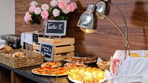 En buffet med forskellige bagværk, brød og et skilt der siger "Smag på det".