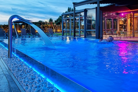 Una piscina al aire libre, sombrillas, sillones reclinables de piscina