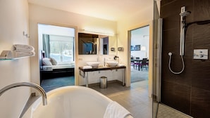 Une salle de bain moderne avec une baignoire sur pieds, une douche et un meuble-lavabo avec un miroir.