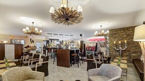 Rebedor modern d'un hotel amb zona de bar, seients i il·luminació decorativa.