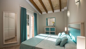 Un dormitorio con una cama, una mesita de noche, un espejo y una ventana con cortinas.