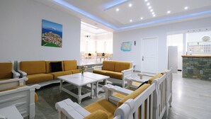 Un moderno vestíbulo de hotel con un área de estar, una recepción y vista al comedor.