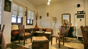 A room with wooden furniture, a desk, a chair, a lamp, and a radiator. - Pela Hotel (Lesvos)