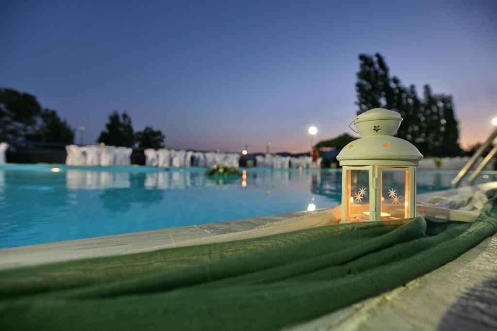 Zona junto a la piscina con un farol y vistas a la pileta.