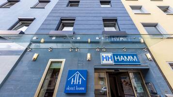 Een hotelentree met een blauw bord waarop