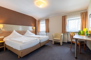 A hotel room with a bed, two bedside tables, a chair, a desk, and a lamp. - Trip Inn Hotel Hamm Koblenz (Koblenz)