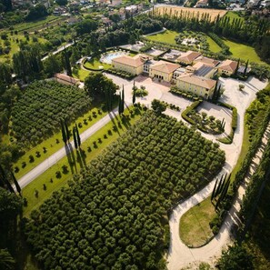 Vista aérea de una extensa propiedad con un patio central, jardines circundantes y varios edificios.