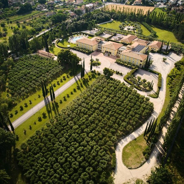 An aerial view of a large estate with a central courtyard, surrounding gardens, and multiple buildings. - Delfina Palace (Foligno)
