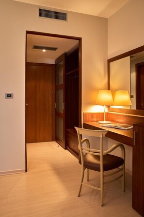 A hotel room with a desk, chair, and a mirror. - Delfina Palace (Foligno)
