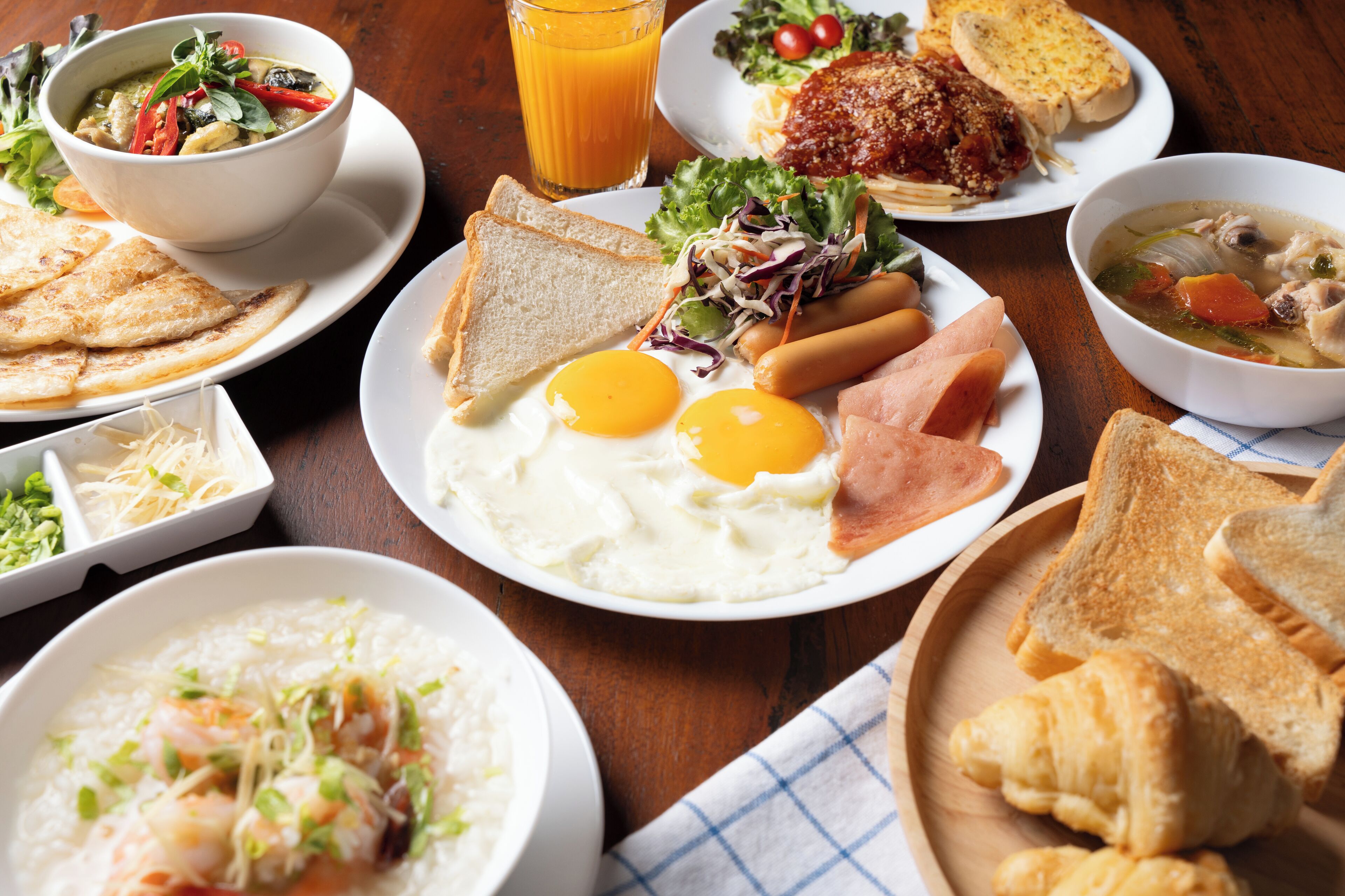 Un assortiment de plats variés pour le petit-déjeuner, comprenant des œufs, des toasts et de la soupe.