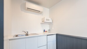 A compact kitchen with a built-in sink, a microwave, and a refrigerator.