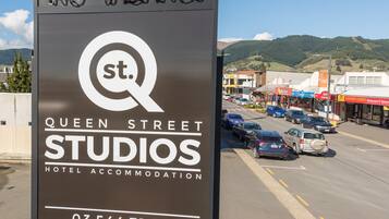 A sign for Queen Street Studios Hotel Accommodation with a vacancy notice.
