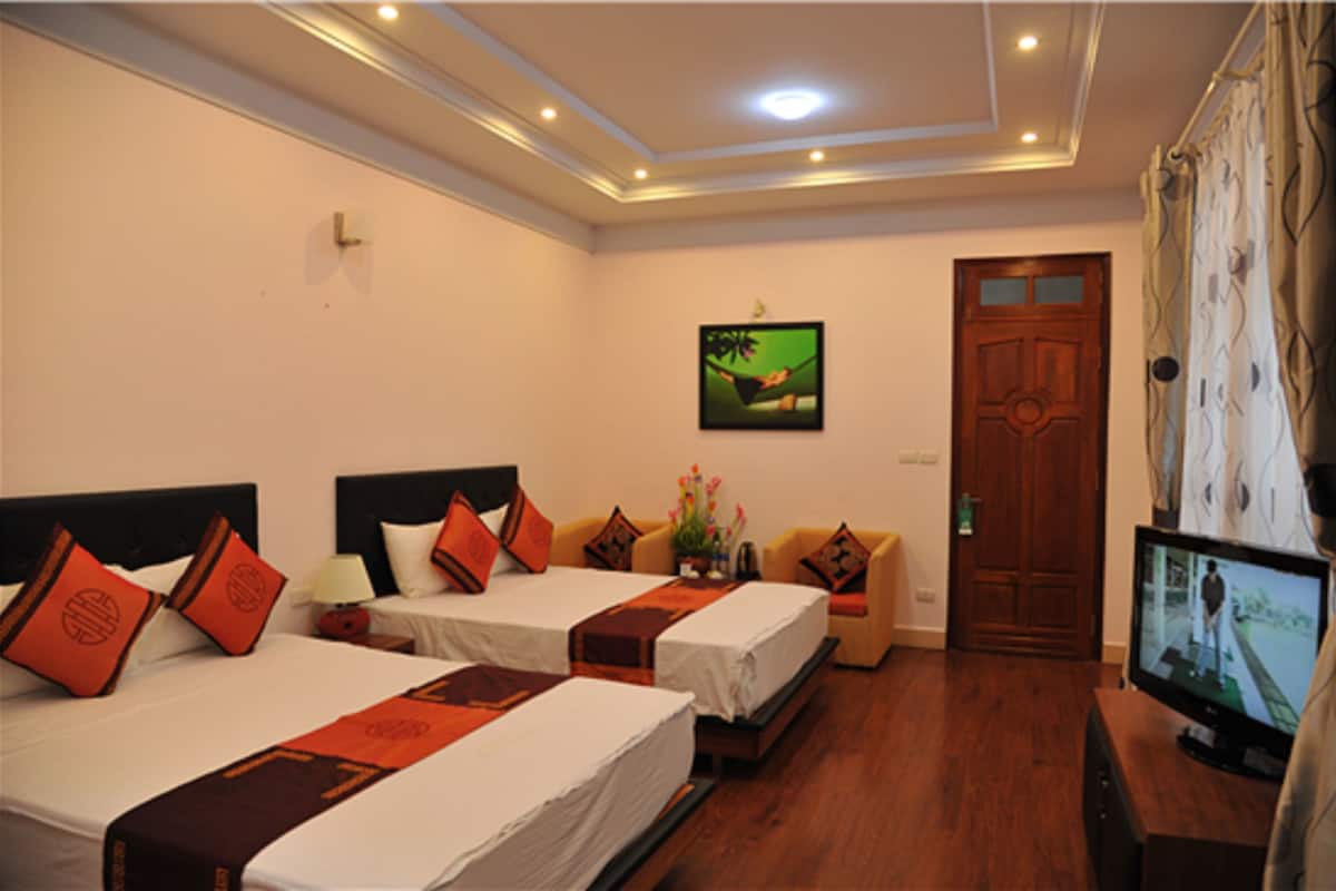 A hotel room with two beds, a television, and a door.