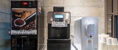 Eine Kaffeemaschine mit digitalem Display und einem Wasserhahn, der blau beleuchtet ist.