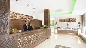 Zona de recepción con elaborados trabajos de madera, mostrador de recepción y un mostrador con exhibición de joyería.