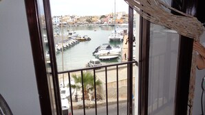 Un balcón con vista a un puerto deportivo y edificios.