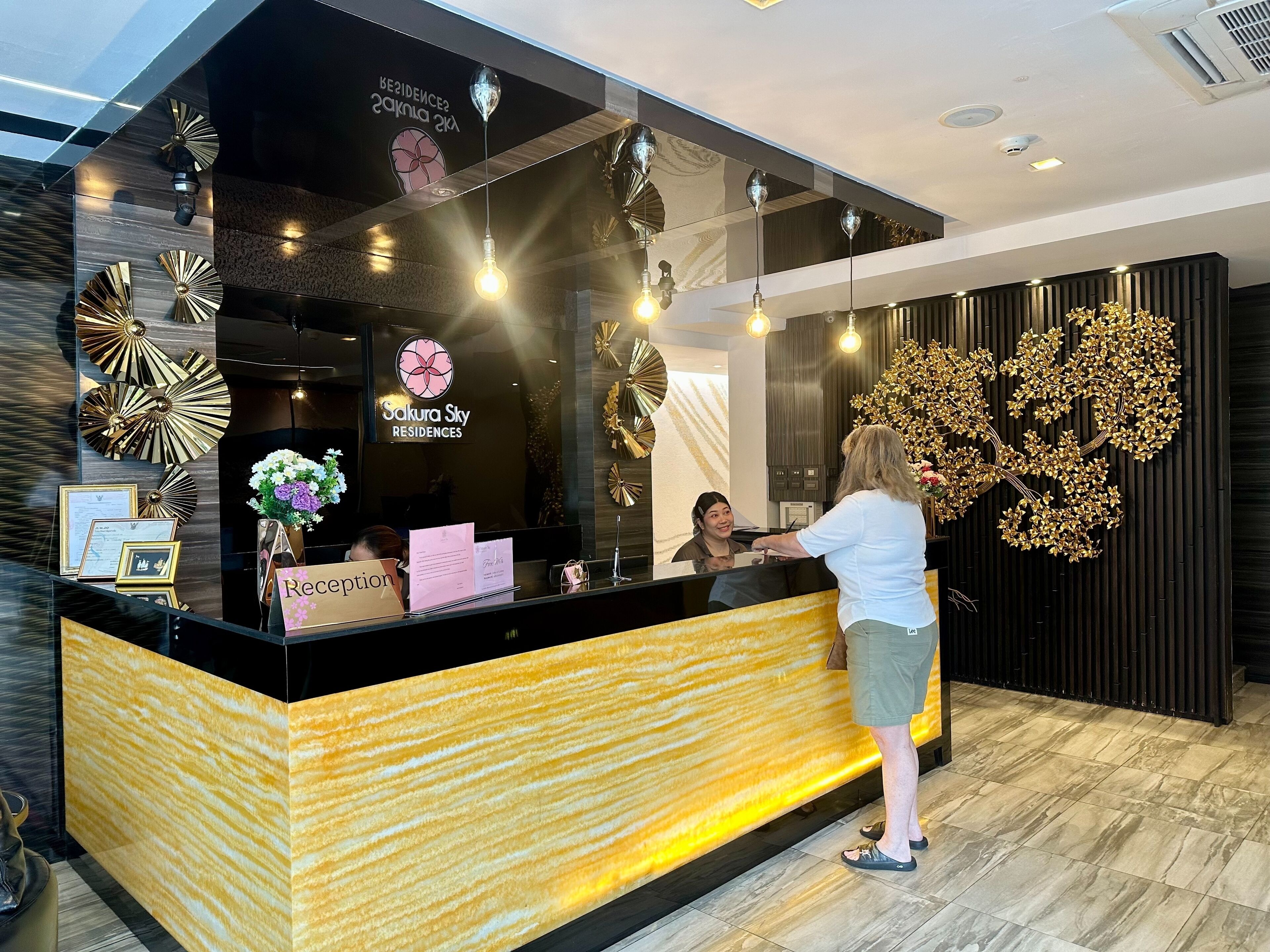A reception desk with a modern design, including a black counter and decorative wall art.