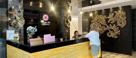 A reception desk with a modern design, including a black counter and decorative wall art.