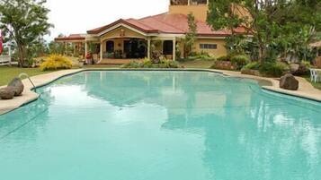 Piscina com uma casa ao fundo.