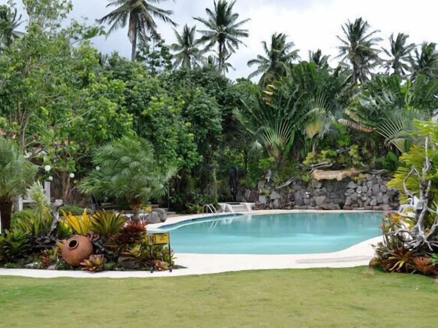 Een buitenzwembad, ligstoelen bij het zwembad