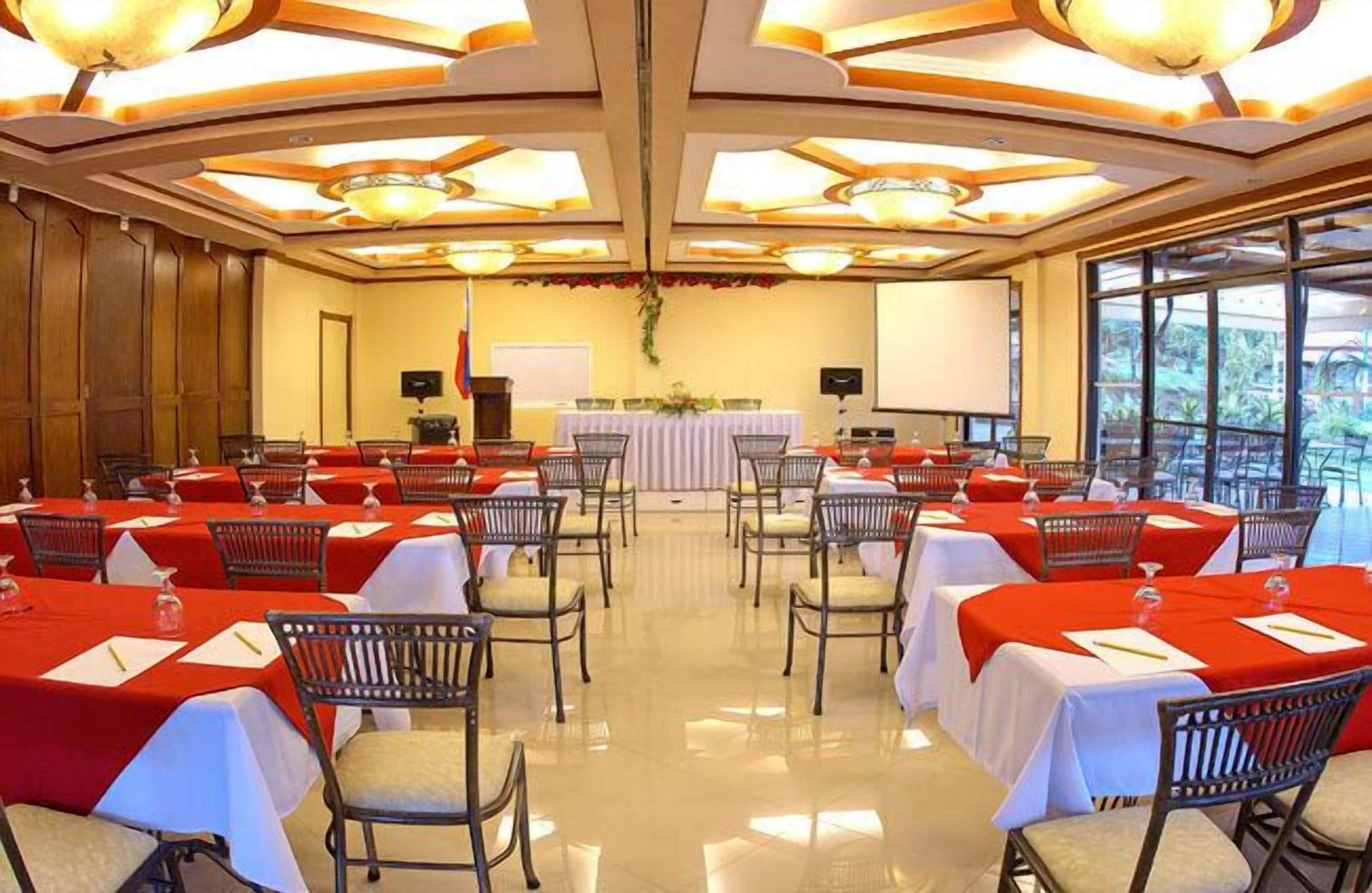 A conference room with multiple tables, chairs, and a podium.