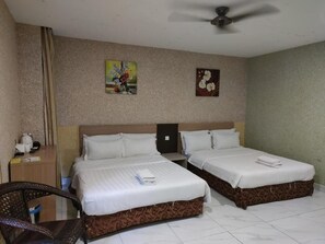A hotel room with two beds, a desk, a chair, and a ceiling fan. - Beez Hotel Shamelin (Kuala Lumpur)