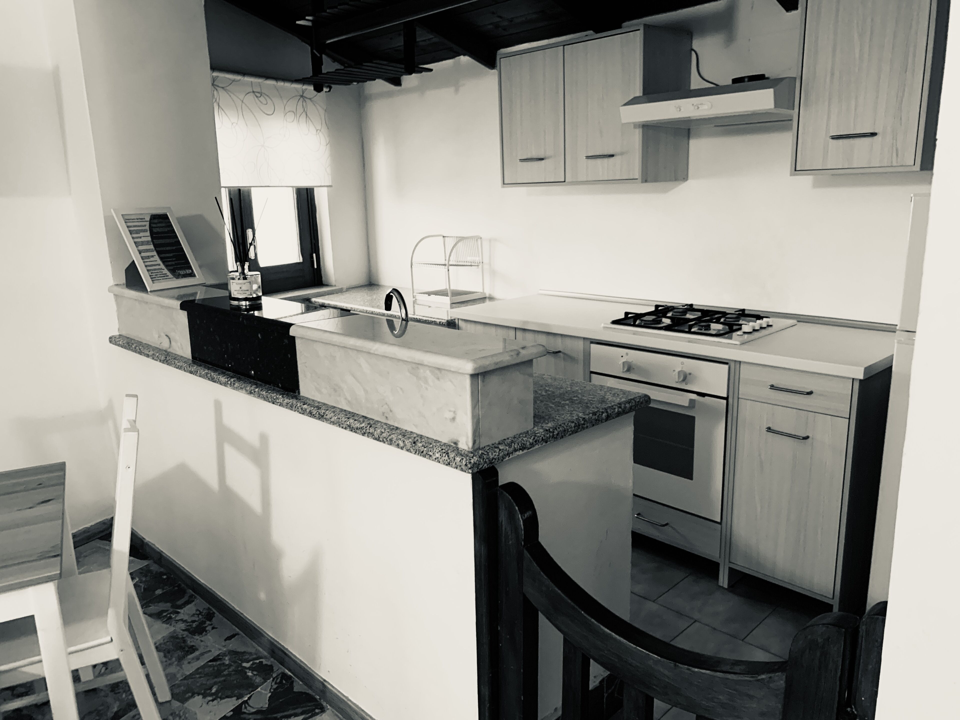 Una cocina moderna con encimera de granito, electrodomésticos de acero inoxidable y armarios de madera.
