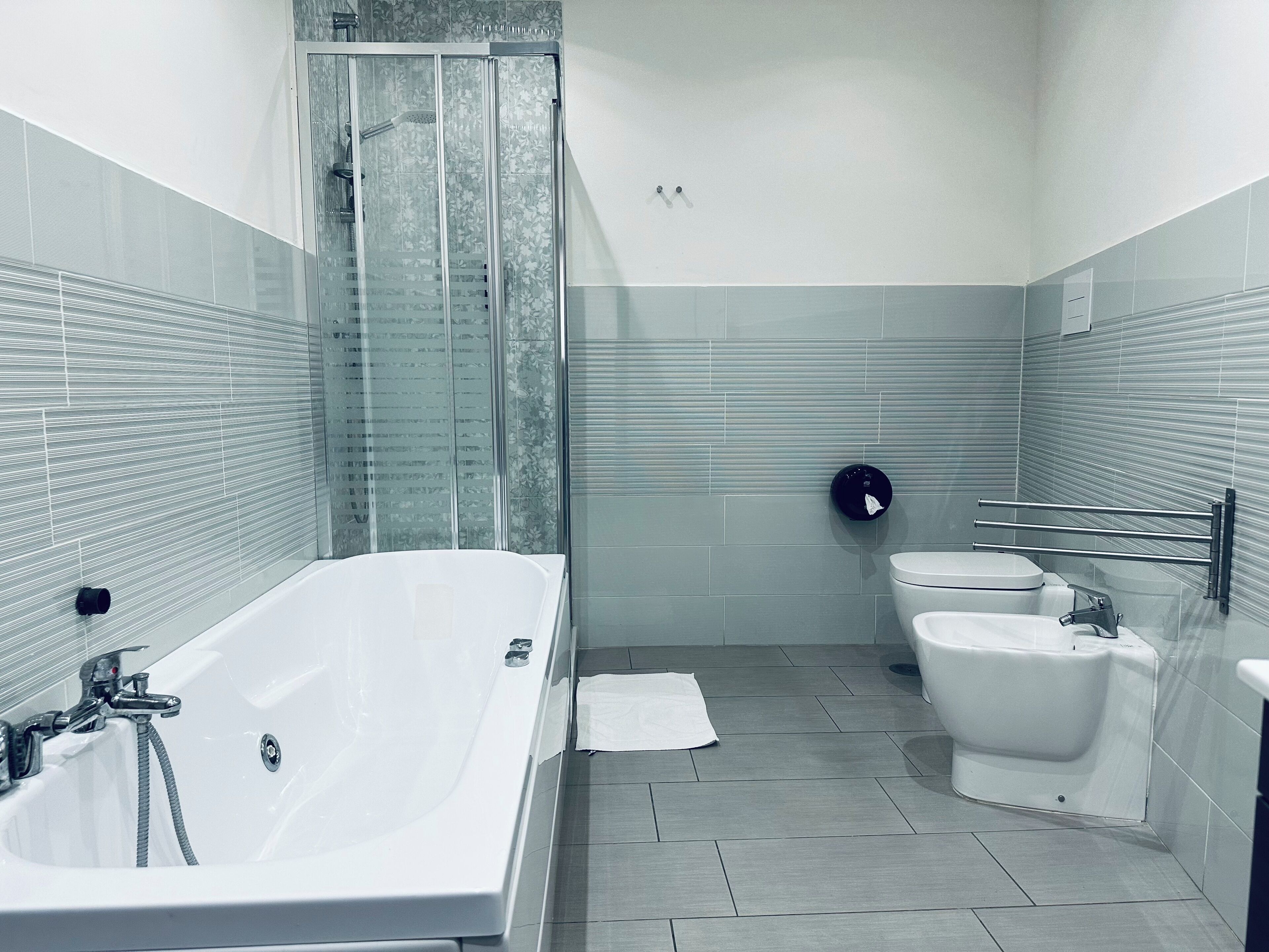 Un baño moderno con una bañera grande, cabina de ducha y un inodoro.