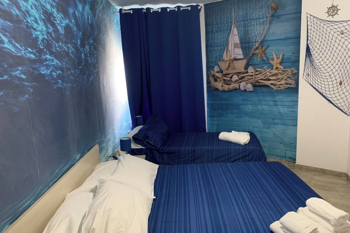 A bedroom with a bed, a nightstand, and a wall mural.