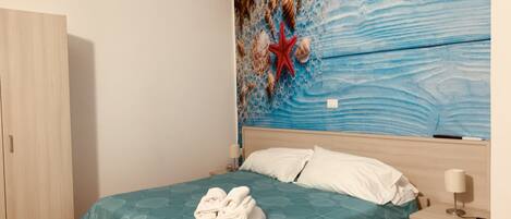 Une chambre à coucher comprenant un lit, une table de chevet, une armoire et une fresque murale.