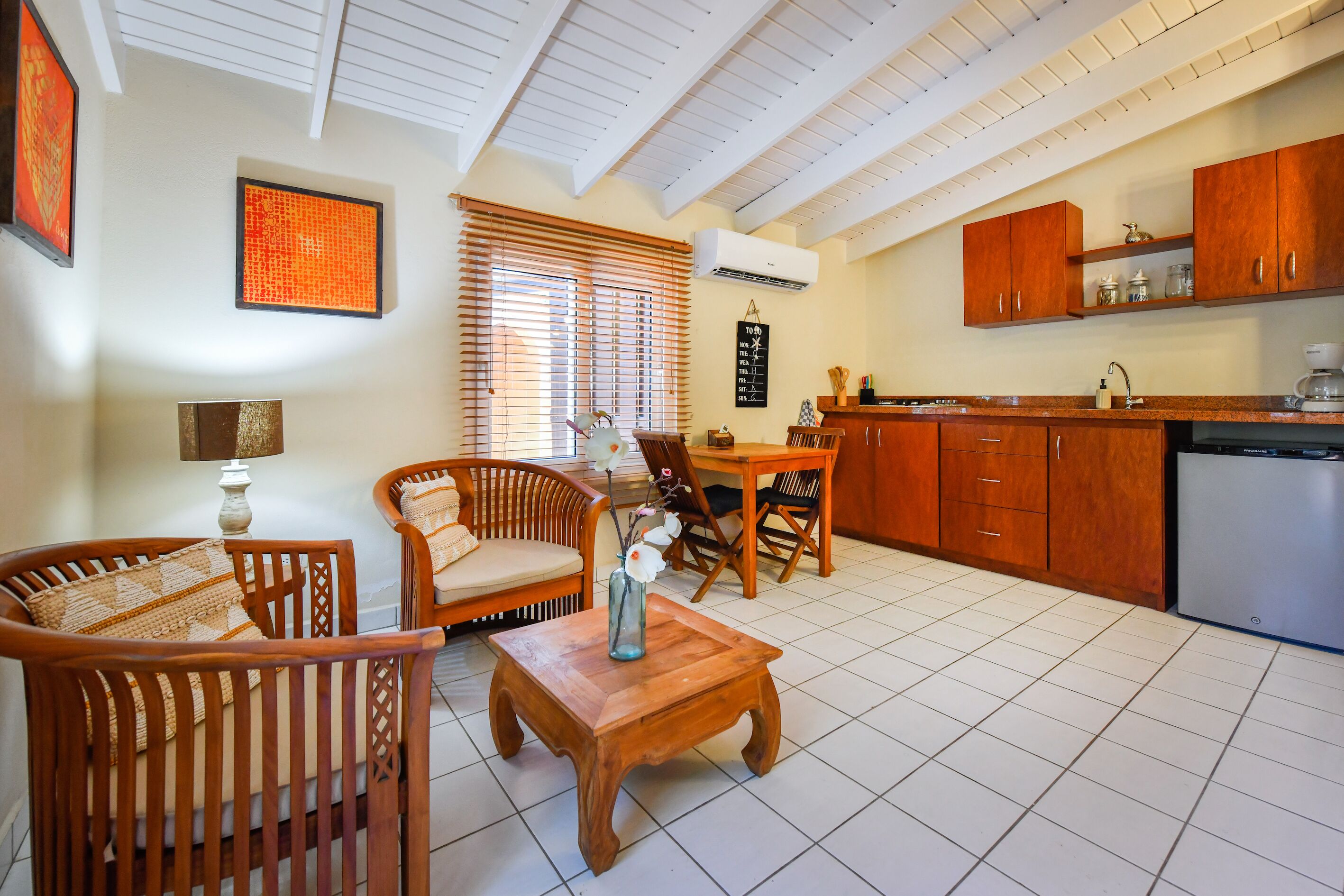 A spacious living area with a dining table, chairs, and a coffee machine.