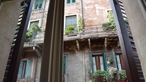 Un edificio de varios pisos con balcones, algunos con plantas y flores.