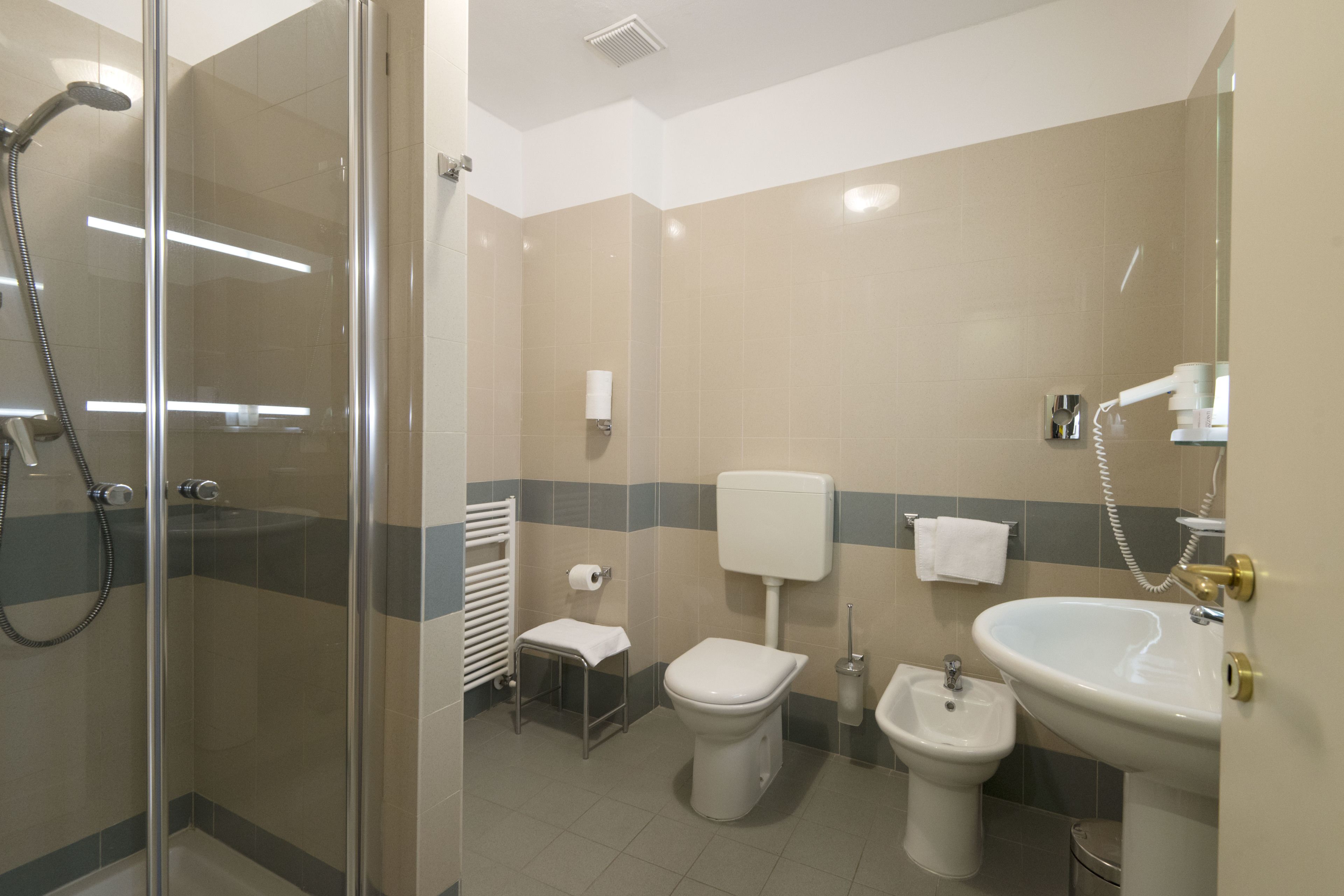 Une salle de bain moderne avec une douche à parois de verre, des toilettes, un bidet et un lavabo.