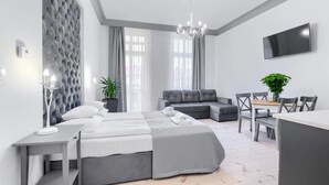 Una habitación de hotel moderna con una cama, zona de estar y televisor.