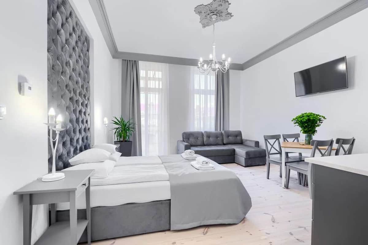 Una habitación de hotel moderna con una cama, zona de estar y televisor.