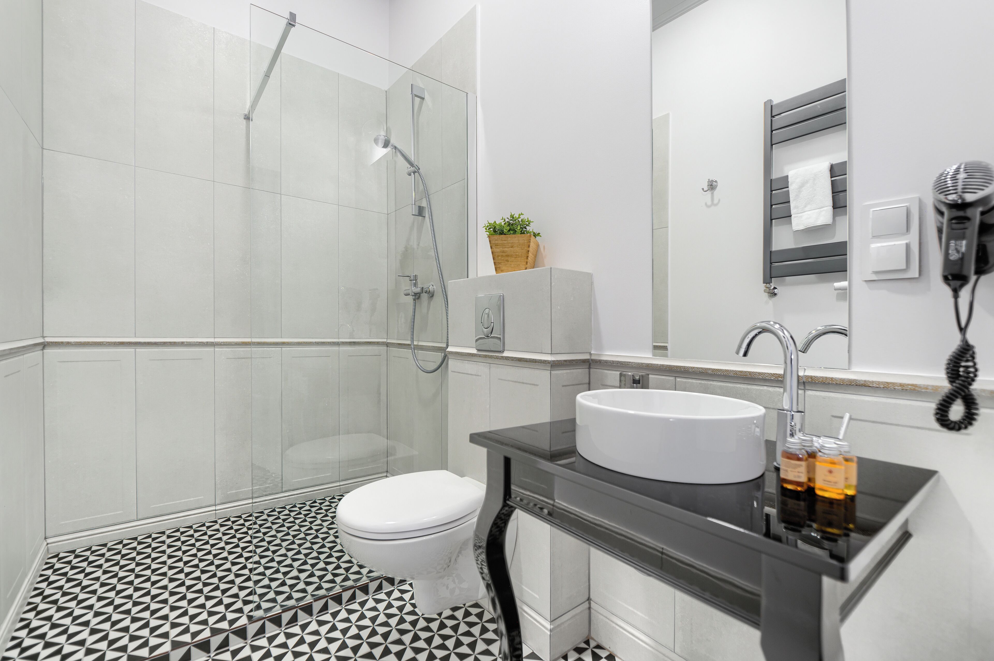 A modern bathroom with a shower, toilet, and sink.