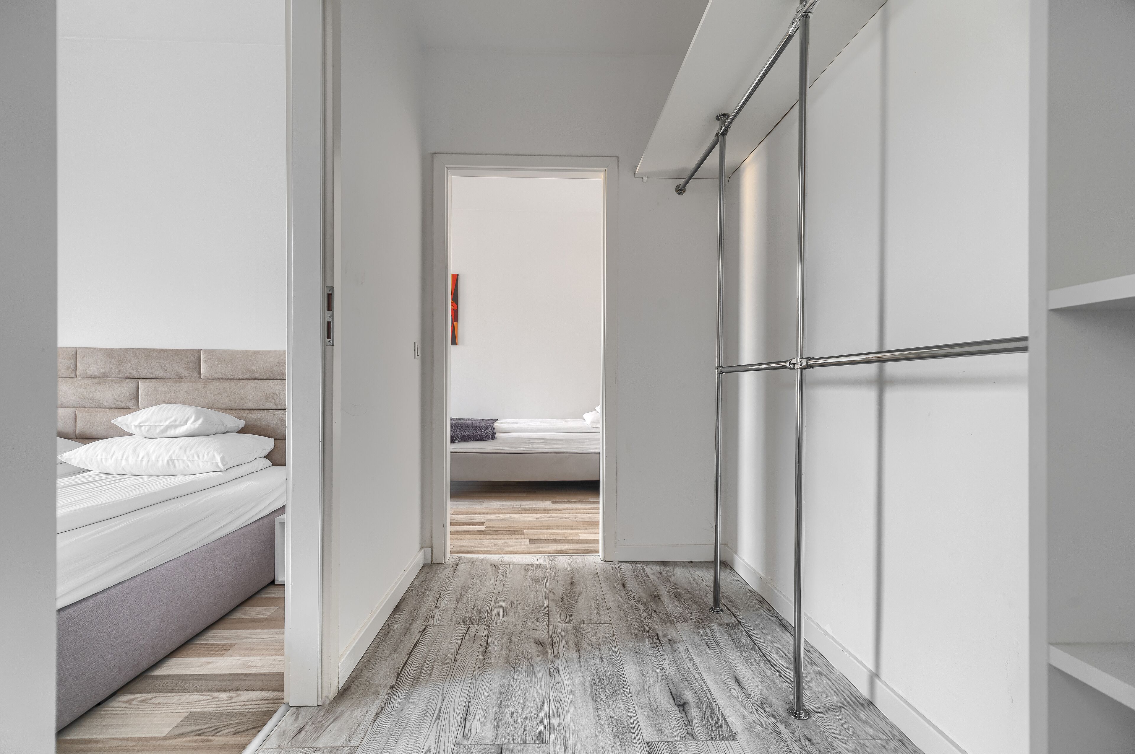 Un couloir étroit, avec un lit à gauche et une armoire à droite.
