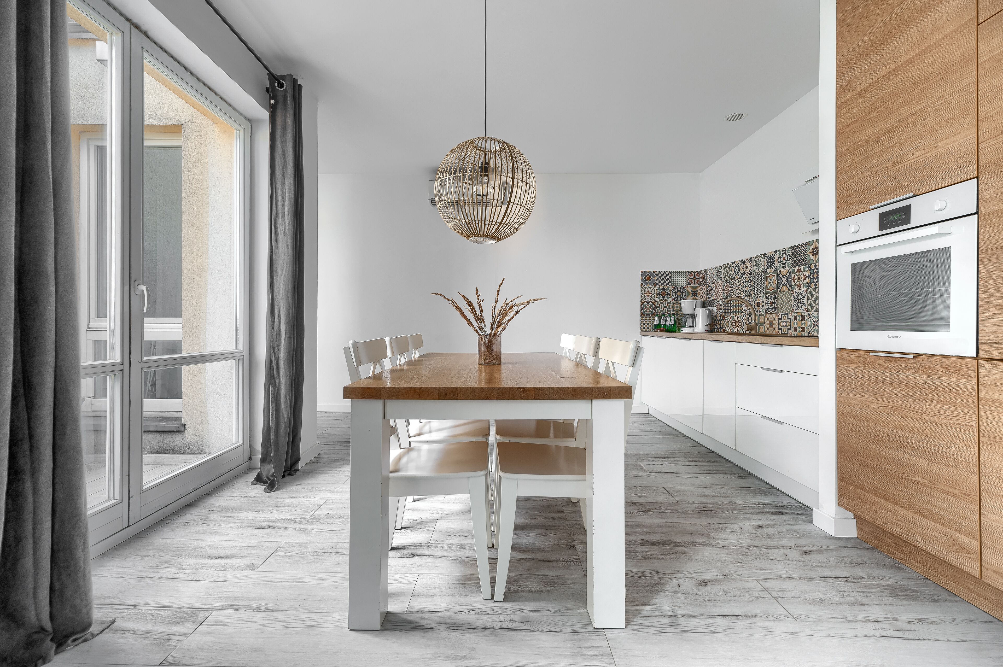 A modern kitchen with white cabinets, a wooden countertop, and a built-in oven.