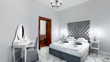 Una camera da letto con un letto, una toeletta con specchio, un comodino e un lampadario.
